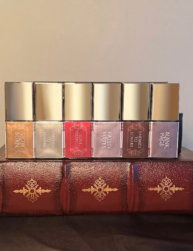 Maison of Stories First Editions Collection six body oil 15ml bottles spine view showing all scent names in gold lettering on vintage leather-bound books