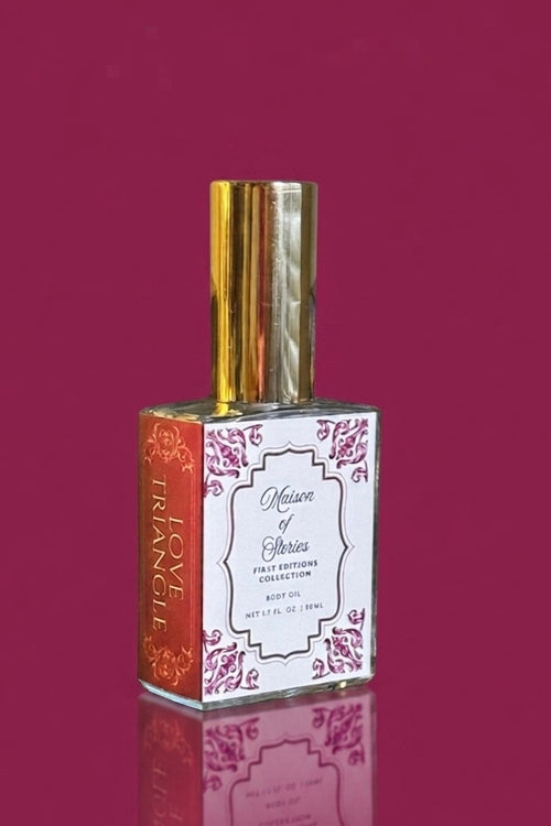 Maison of Stories Love Triangle body oil in a clear glass bottle with gold cap set against a rich berry pink background